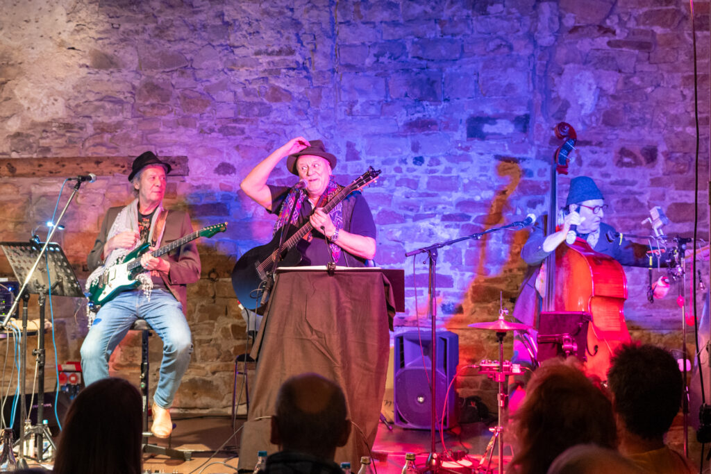 Ein Bild der 3 Musiker der EHL-Band, Eddy hat seine Hand am Hut